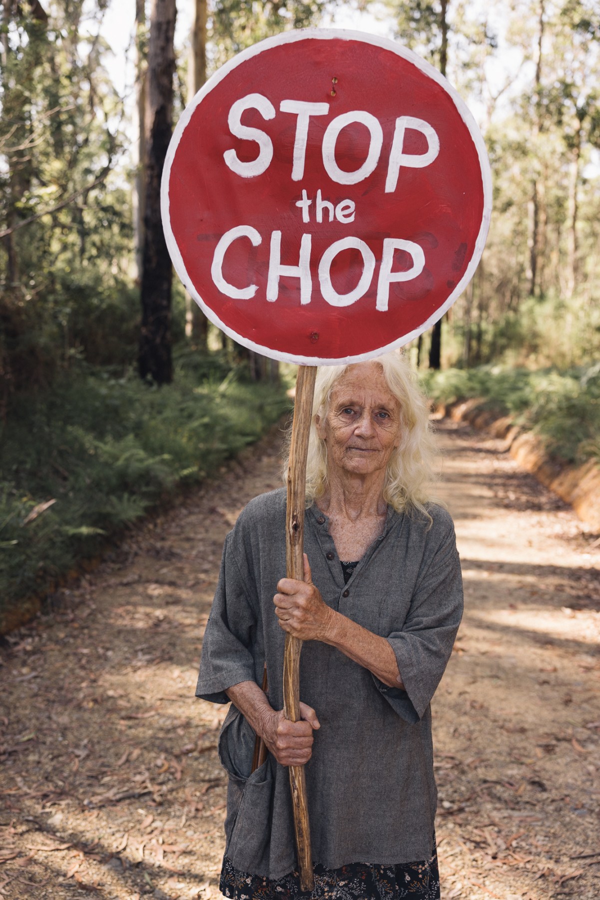 a peaceful protestor holding a 'stop the chop' poster